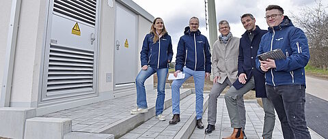 Mitarbeitende vor moderner Trafostation zur Sicherung der regionalen Stromversorgung.