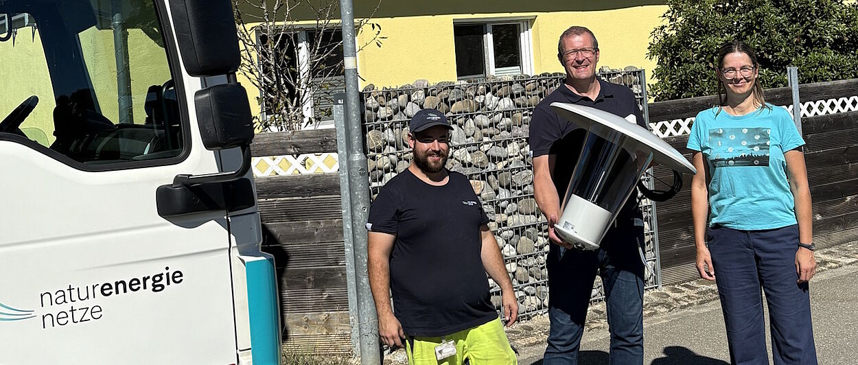 Zwei Männer und eine Frau mit einer LED-Straßenlaterne