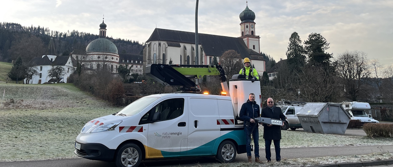 Drei Personen vor einem Fahrzeug